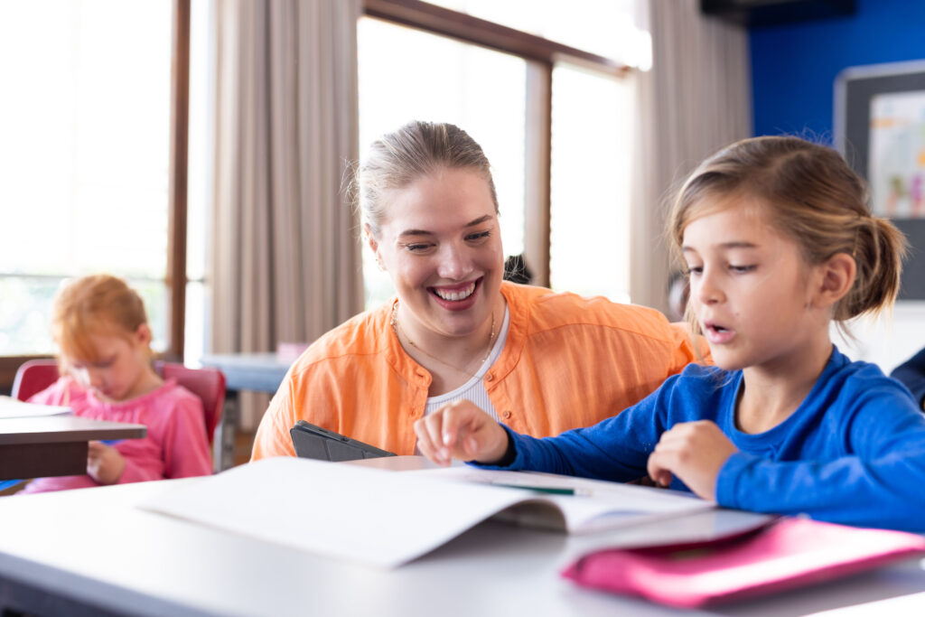 Leerkracht helpt leerlingen in de klas