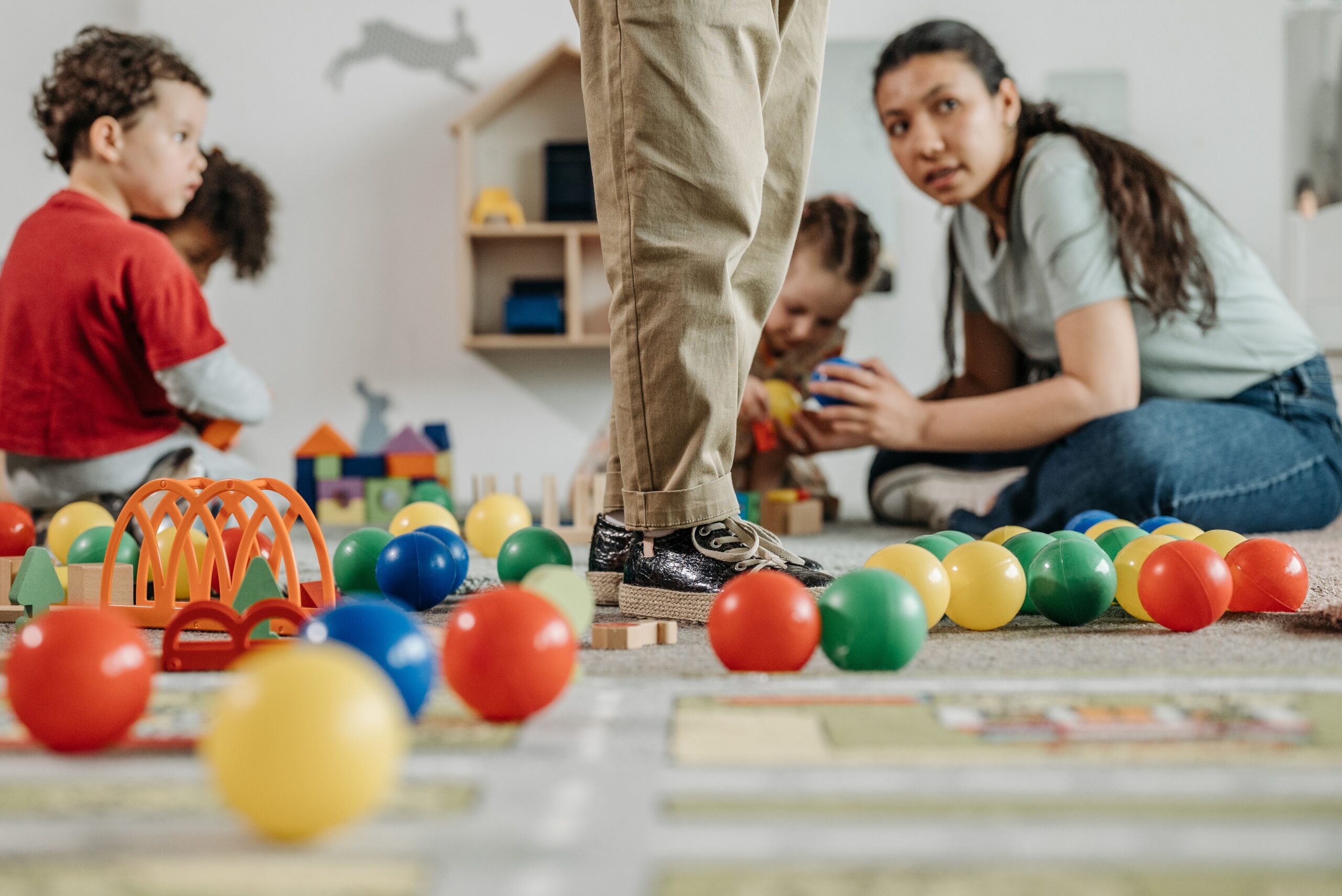 Pedagogisch medewerker speelt met kinderen in de kinderopvang
